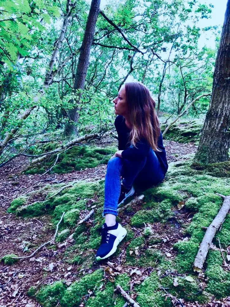 Maja Busch sitzt entspannt im Wald
